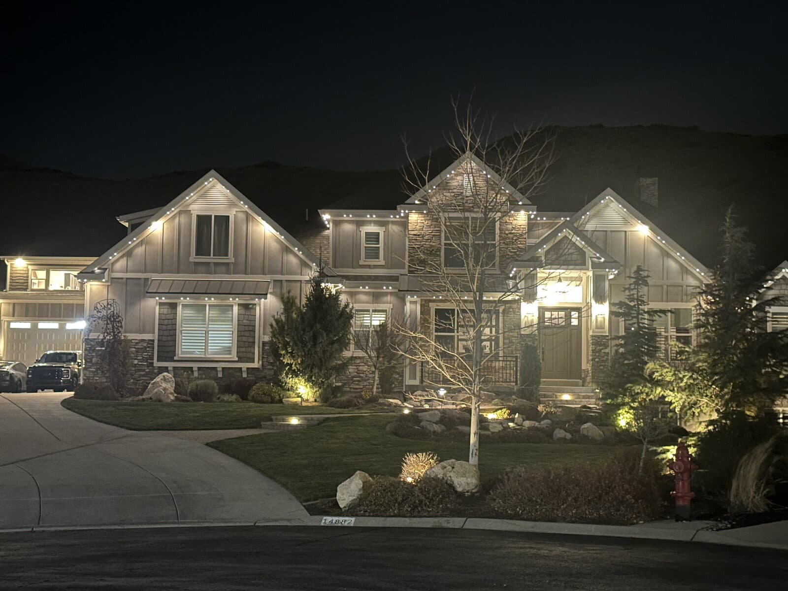 Real Alta permanent install in warm white with lit landscaping